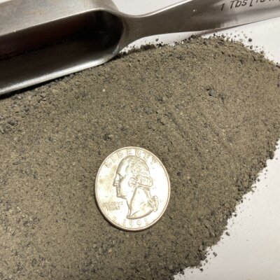 Basalt rock dust with US quarter for scale shows fine texture of the material.